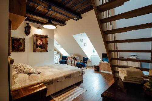 ein Schlafzimmer mit einem Bett in einem Zimmer mit einer Treppe in der Unterkunft Dom Berg in Banská Štiavnica
