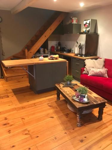 - un salon avec un canapé rouge et une table dans l'établissement Maison atypique, à Brando