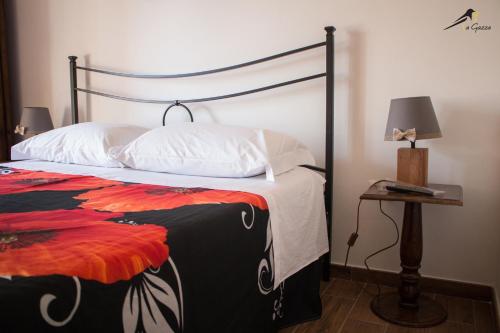 a bedroom with a bed and a table with a lamp at La Gazza in Viterbo