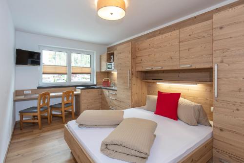 - une chambre avec un grand lit et un oreiller rouge dans l'établissement GIGGI Tenne Studios, à Sölden
