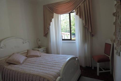 Un dormitorio con una cama grande y una ventana en BLISS BOHO HOUSE, en Sintra