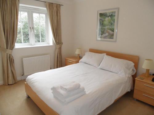 a bedroom with a white bed with towels on it at Westlands House, City Centre, Home-From-Home in Basingstoke