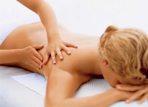 a woman laying on a bed with her hands on her body at Kaani Village & Spa in Maafushi