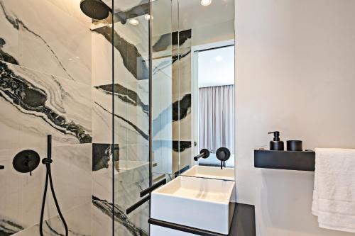 a bathroom with a sink and a glass shower at Constantinos Villa, Sublime Island Εscape, By ThinkVilla in Panormos Rethymno