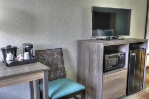 a room with a table and a chair and a tv at Pigeon River Inn in Pigeon Forge