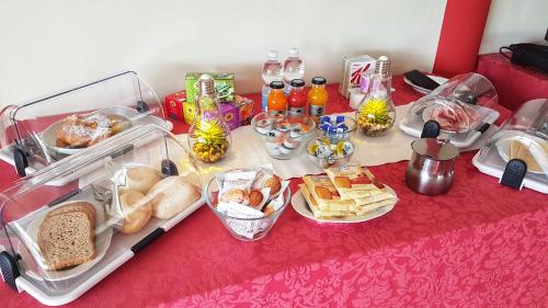 Asso Bed & Breakfast في مانربا ديل جاردا: طاولة مع طعام ومشروبات على طاولة حمراء