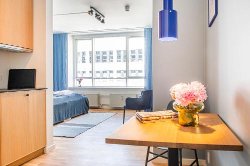 a room with a table with a vase of flowers on it at The Lakes apartments by Daniel&Jacob's in Copenhagen