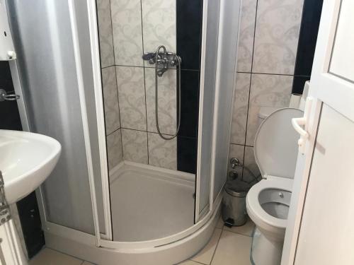 a bathroom with a shower with a toilet and a sink at Likya Pansiyon in Kaleucagız