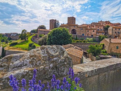 a view of a city with purple flowers at LA PICCOLA DEPENDANCE in Tuscania