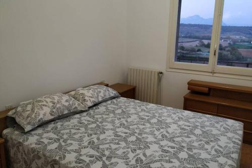 um quarto com uma cama com um cobertor e duas janelas em Vidal Rural em Aviá