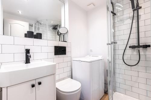 a white bathroom with a toilet and a shower at Oma Lieschen in Keitum