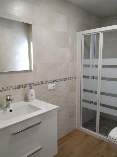 uma casa de banho com um lavatório branco e um chuveiro em Vidal Rural em Aviá