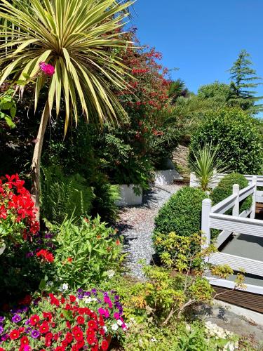 a garden with flowers and a white fence at The Earlsdale Bed and Breakfast in Ilfracombe