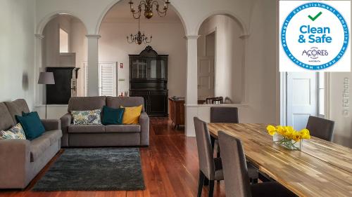a dining room and living room with a table and chairs at CC Guest House - "Ao Mercado" in Ponta Delgada