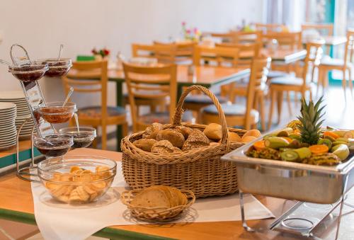 a table with a basket of food and glasses of wine at CVJM Familienferienstätte Huberhaus in Wernigerode