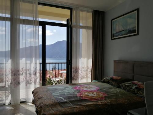 a bedroom with a bed and a view of the ocean at Apartments FANTASY in Kotor