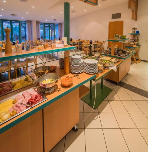 - une ligne de buffet dans un restaurant avec des plats en vedette dans l'établissement CVJM Familienferienstätte Huberhaus, à Wernigerode