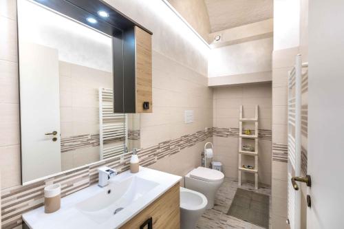 a bathroom with a sink and a toilet and a mirror at Green house in Orvieto