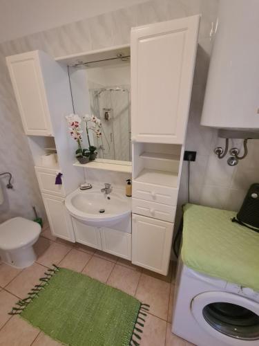 a white bathroom with a sink and a toilet at Villa Antonio in Opatija
