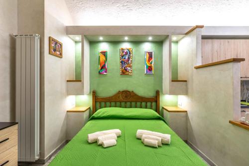a bedroom with a green bed with towels on it at Green house in Orvieto