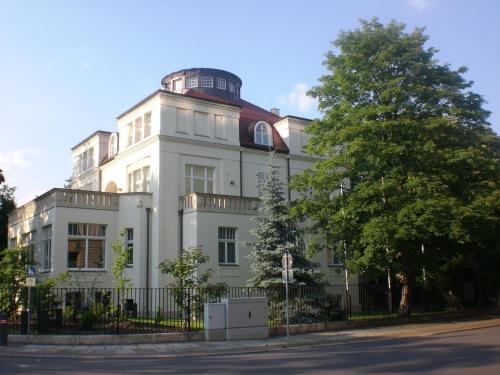 a white building with an observatory on top of it at Gästehaus Leipzig in Leipzig