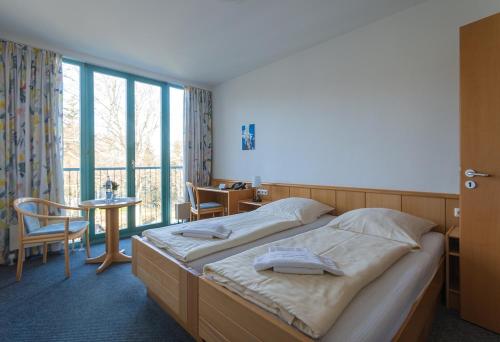 - une chambre avec un grand lit et une grande fenêtre dans l'établissement CVJM Familienferienstätte Huberhaus, à Wernigerode