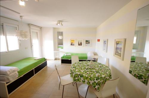 Habitación con mesa, cama y comedor. en Livingtarifa Carpe Diem, en Tarifa