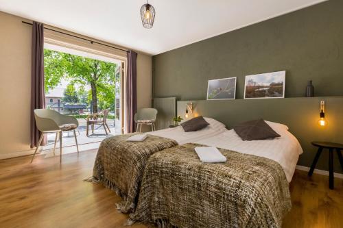a bedroom with two beds and a large window at Hotel Restaurant In d'Ouwe Peel in Helenaveen