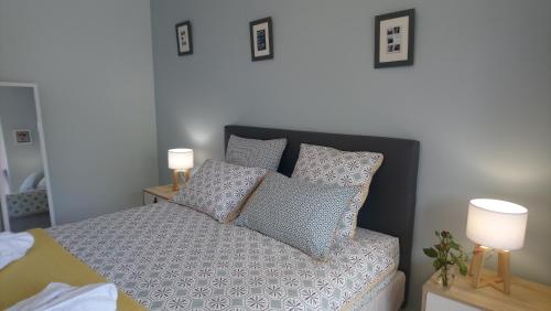a bedroom with a bed with pillows and two lamps at Fleurs de Cosmos in Albi