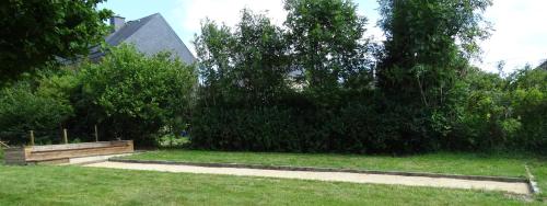 a park with a bench and trees and a building at Au Frêne Centenaire in Bras