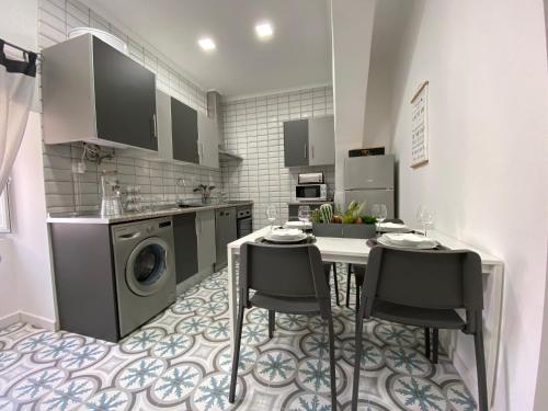 eine Küche mit einem Tisch und Stühlen sowie einer Waschmaschine in der Unterkunft Largo d Vizinha Bia in Elvas
