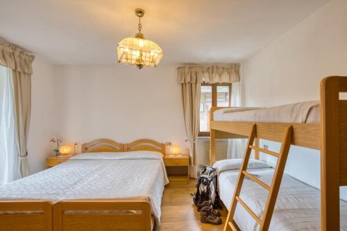 a bedroom with two bunk beds and a chandelier at Albergo Moleta in Spiazzo