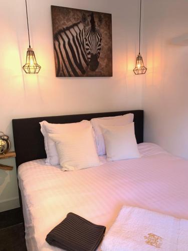 um quarto com uma cama com uma foto de uma zebra em Finch guesthouse em Zandvoort