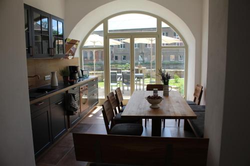 a kitchen with a table and a large window at Ferienwohnung Kapplermühle in Bautzen