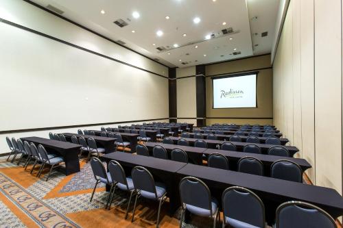 an empty lecture hall with a screen and chairs at Radisson Hotel Curitiba in Curitiba