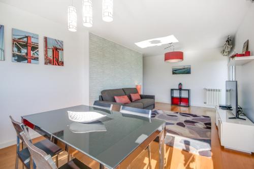 eine Küche und ein Wohnzimmer mit einem Tisch und einem Sofa in der Unterkunft Welcome Here - Tamisa - Parque das Nações in Lissabon