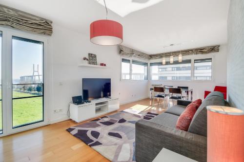 a living room with a couch and a tv at Welcome Here - Tamisa - Parque das Nações in Lisbon