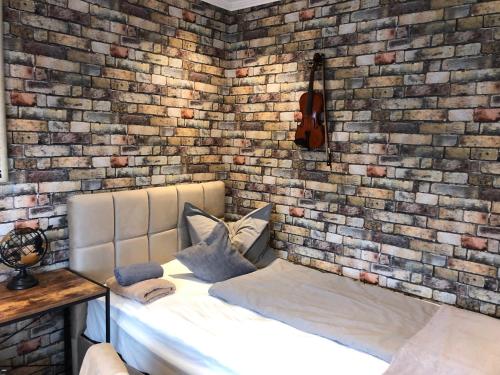 a bedroom with a brick wall and a bed at Pension Ottenheide in Schloß Holte-Stukenbrock