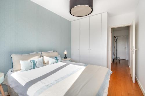 a bedroom with a white bed with a blue wall at Welcome Here - Tamisa - Parque das Nações in Lisbon