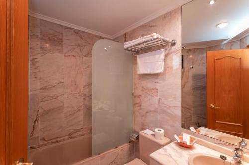 a bathroom with a sink and a toilet and a tub at Astures in Oviedo