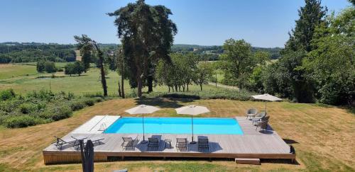an overhead view of a swimming pool with chairs and umbrellas at Reids Retreat in La Roche-lʼAbeille