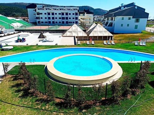 - une vue sur la grande piscine bleue dans l'établissement QH Praia de Quiaios, à Praia de Quiaos