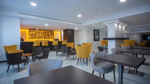 a restaurant with tables and chairs and a bar at QH Praia de Quiaios in Praia de Quiaios