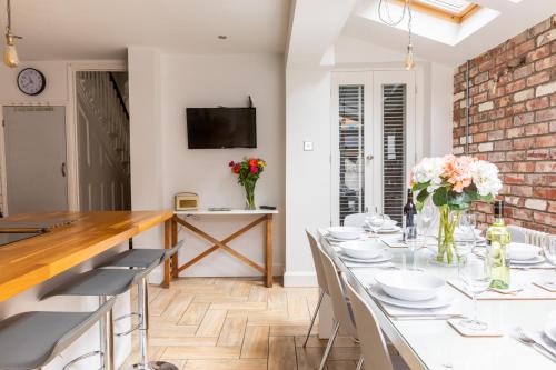 a dining room with a table with white plates and flowers at 39 Hamilton Street in Cardiff