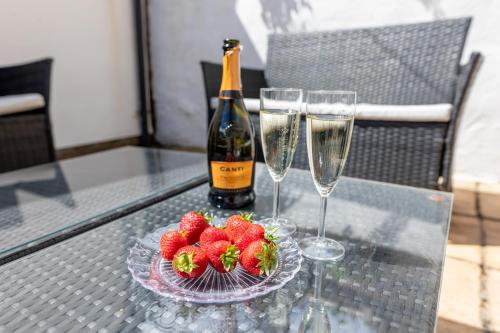a table with two glasses and a bottle of wine and strawberries at 39 Hamilton Street in Cardiff