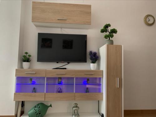 a entertainment center with a television in a living room at ATICO LA ILUSION CON PARkING in Sanlúcar de Barrameda