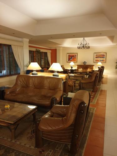 a living room with leather couches and a table at Santarem Hotel in Santarém