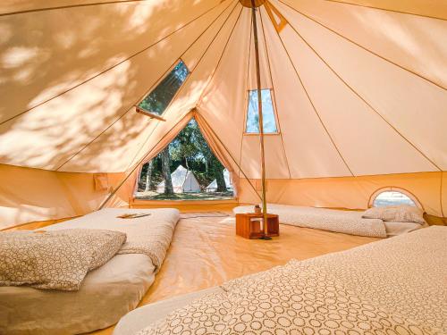 une chambre avec deux lits dans une tente dans l'établissement WolfCamp Surf Moliets, à Moliets-et-Maa