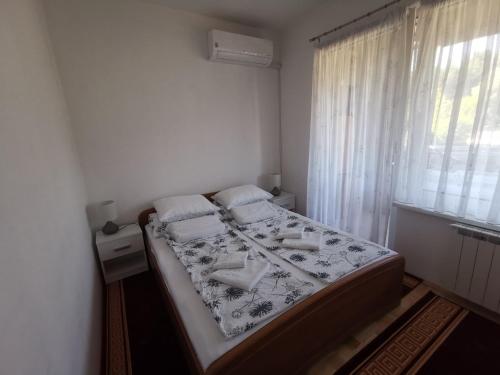 a bedroom with a bed and a window at Apartman Banja - Tuzla in Tuzla