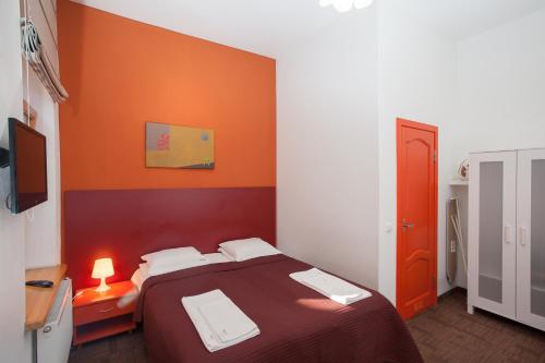 a bedroom with a bed with an orange wall at Moja Accommodation in Kaunas